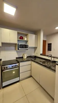 a kitchen with white cabinets and a stove at Departamento en Opera fun 2nd piso in Villa Carlos Paz