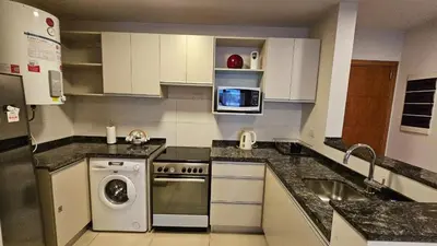 a kitchen with a washer and a microwave at Departamento en Opera fun 2nd piso in Villa Carlos Paz