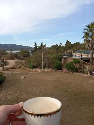 a person holding a cup of coffee in a park at Casa Lago Azul in Villa Santa Cruz del Lago