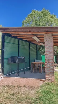 a screened in porch with a table and a grill at Casa Lago Azul in Villa Santa Cruz del Lago