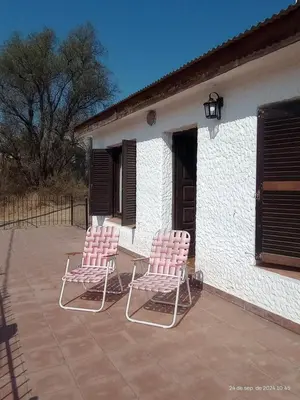 two pink chairs sitting on a patio next to a building at Hermosa Casa para 6 personas en Parque Siquiiman Cordoba in Villa Parque Siquiman