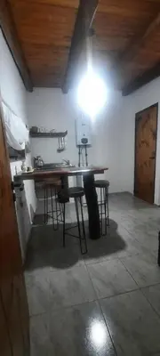 a room with a table with chairs and a light at Cabaña Paz in Santa Rosa de Calamuchita