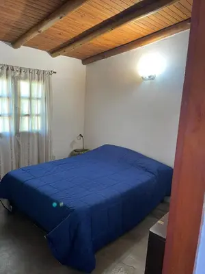 a bedroom with a blue bed in a room at Cabañas Doña Chicha - San Clemente, Córdoba in San Clemente