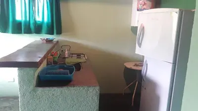 a kitchen with a counter and a refrigerator at Cabañas Doña Chicha - San Clemente, Córdoba in San Clemente
