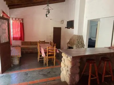 a living room with a table and chairs and a couch at Cabañas Doña Chicha - San Clemente, Córdoba in San Clemente
