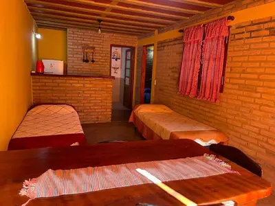 a room with two beds and a brick wall at Cabañas Doña Chicha - San Clemente, Córdoba in San Clemente