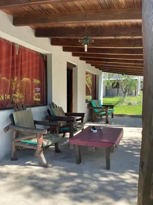 a patio with benches and a table and a ceiling at Cabañas Doña Chicha - San Clemente, Córdoba in San Clemente