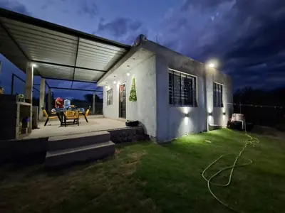 a small house with a patio at night at Cabaña la Fride in Cosquín