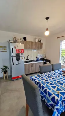 a kitchen with a refrigerator and a table and chairs at Cabaña la Fride in Cosquín