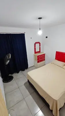 a bedroom with a bed and a blue curtain at Cabaña la Fride in Cosquín