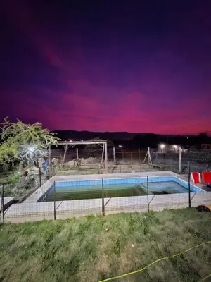 a swimming pool at night with a purple sky at Cabaña la Fride in Cosquín