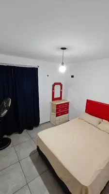 a bedroom with a bed and a red dresser at Cabaña la Fride in Cosquín