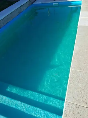 a large blue swimming pool with blue water at Cabaña la Fride in Cosquín