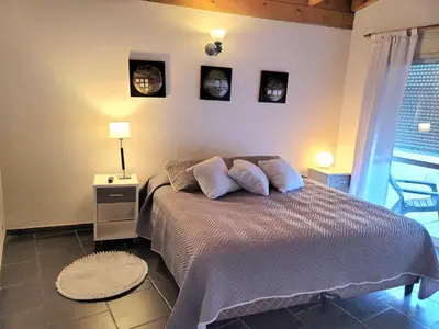 a bedroom with a bed with three pictures on the wall at Mona Suites in Cordoba