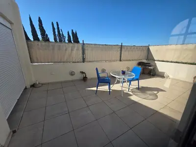 a patio with two chairs and a table on a balcony at Mona Suites in Cordoba