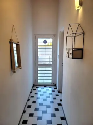 a hallway with a window and a black and white tile floor at Mona Suites in Cordoba
