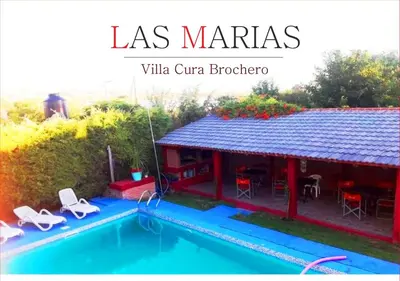 a villa with a swimming pool next to a house at Departamentos Las Marias in Villa Cura Brochero