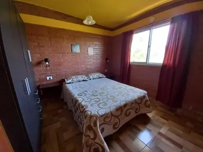 a bedroom with a bed and a window at Departamentos Las Marias in Villa Cura Brochero