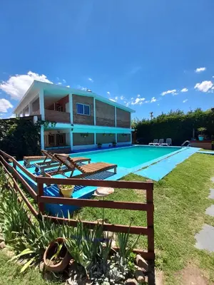 a house with a swimming pool in front of it at Departamentos Las Marias in Villa Cura Brochero