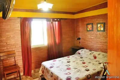 a bedroom with a bed and a window at Departamentos Las Marias in Villa Cura Brochero