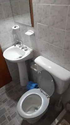a bathroom with a white toilet and a sink at Departamentos Las Marias in Villa Cura Brochero