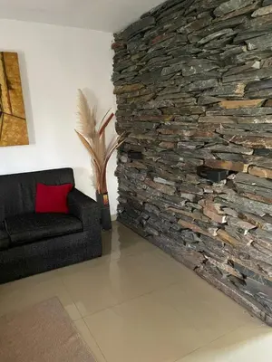 a living room with a stone wall and a couch at Mi casita en Embalse in Embalse