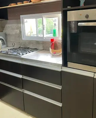 a kitchen with a stove and a microwave at Mi casita en Embalse in Embalse