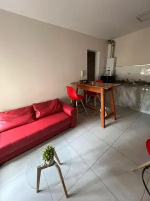 a living room with a red couch and a table at Portal de la Cañada in Cordoba