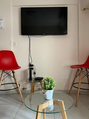 a living room with two chairs and a tv on the wall at Portal de la Cañada in Cordoba