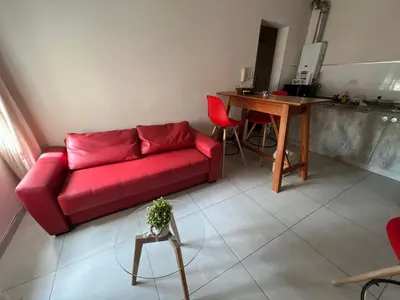 a living room with a red couch and a table at Portal de la Cañada in Cordoba