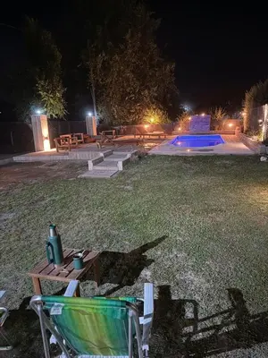 a group of benches and a pool at night at Los viejos Potrero de Garay in Villa Anizacate
