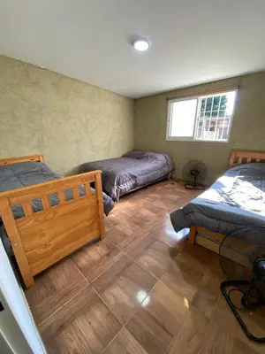 a bedroom with two beds and a wooden floor at Los viejos Potrero de Garay in Villa Anizacate
