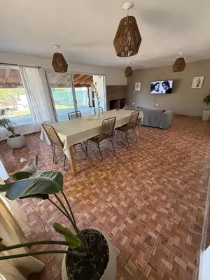 a dining room with a table and chairs and a tv at Los viejos Potrero de Garay in Villa Anizacate