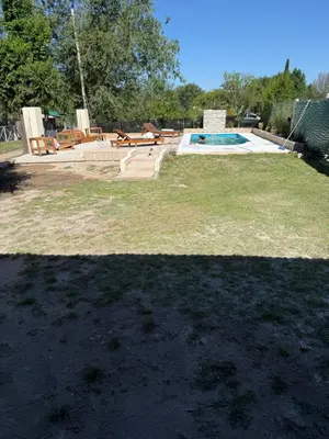 a yard with a swimming pool with benches and afficient at Los viejos Potrero de Garay in Villa Anizacate