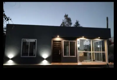 a small house with lights on the front of it at Cabaña Villa Alpina,tanti córdoba in Tanti