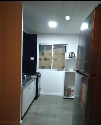 a kitchen with a stove and a refrigerator at Cabaña Villa Alpina,tanti córdoba in Tanti