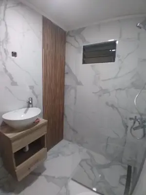 a bathroom with a sink and a white marble wall at Cabaña Villa Alpina,tanti córdoba in Tanti