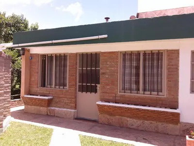 a brick building with a white door and windows at Casa en VCP a la vuelta de la Costanera in Villa Carlos Paz