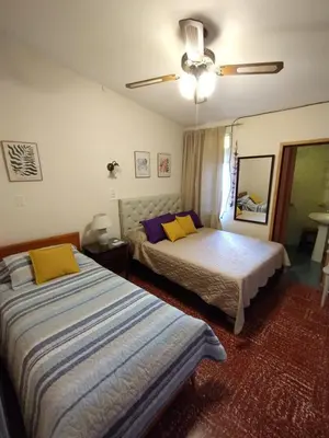 a bedroom with two beds and a ceiling fan at Casa en VCP a la vuelta de la Costanera in Villa Carlos Paz