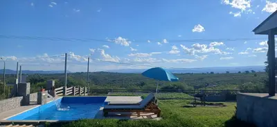 a swimming pool with a blue umbrella and a view at Rincon de Bialet in Bialet Massé