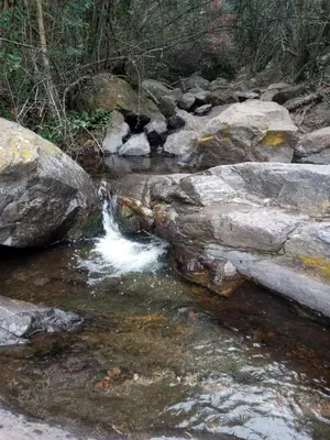 a stream of water flowing over rocks in a river at Ikigai alojamiento con piscina in Villa Rumipal