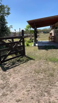 a wooden fence in a field next to a building at Ikigai alojamiento con piscina in Villa Rumipal