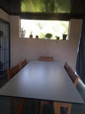 a table in a room with chairs and a window at Cabaña Villa Alpina in Tanti