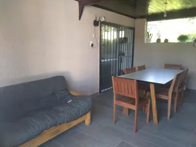 a living room with a couch and a table and chairs at Cabaña Villa Alpina in Tanti