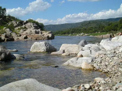 a river with some rocks and some water at Cabaña Villa Alpina in Tanti