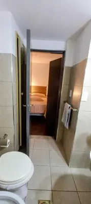 a bathroom with a toilet and a bed in a room at El Valtodano in Cordoba