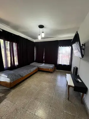 a bedroom with two beds and a table in it at Departamento Santa rita in Villa Carlos Paz