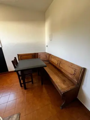 a wooden bench in a room with a table at Departamento Santa rita in Villa Carlos Paz