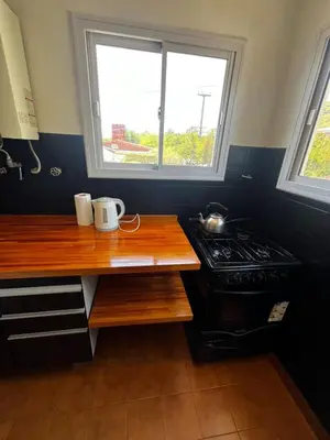 a kitchen with a counter and a stove and a window at Departamento Santa rita in Villa Carlos Paz