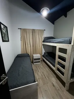 a bedroom with two bunk beds and a window at Altos de Lagunitas in Villa General Belgrano